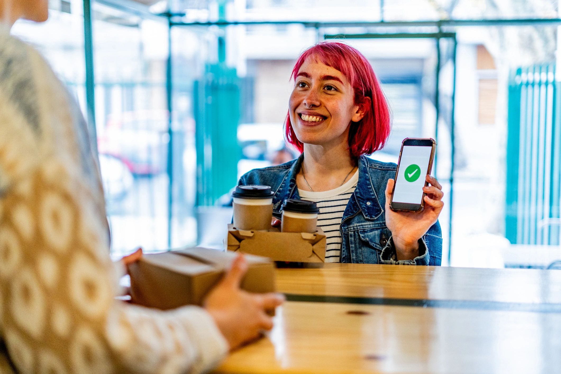 Customer using a phone to scan at a cafe counter