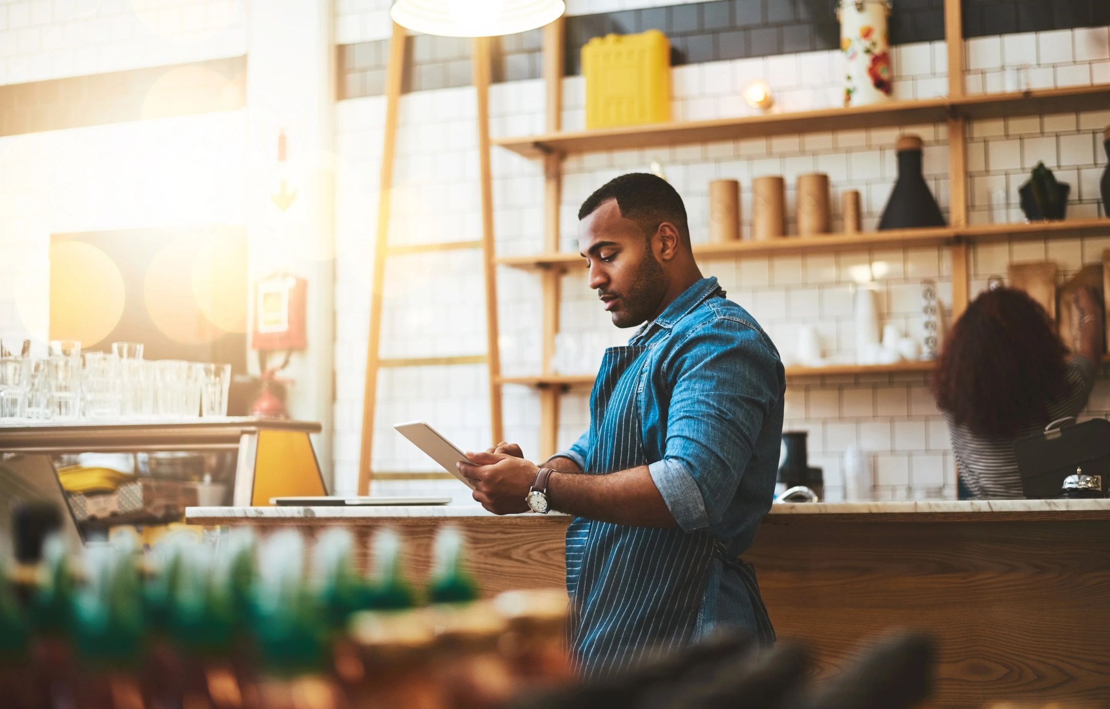 Coffee shop owner working on a tablet at the counter